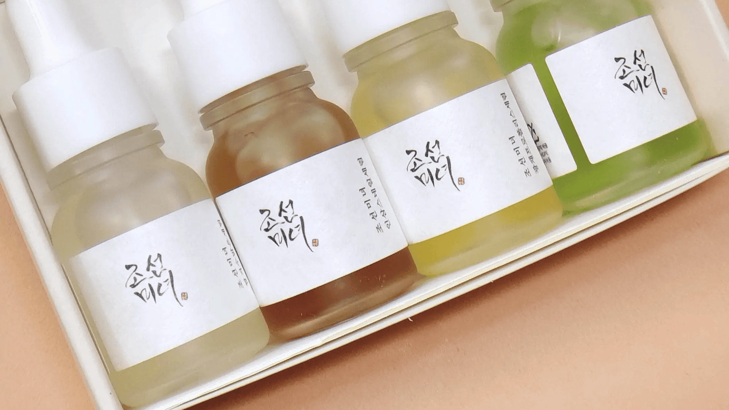 Bilden visar en samling serumflaskor från Beauty of Joseon, som är kända för sina hudvårdsprodukter inspirerade av traditionell koreansk medicin, hanbang.