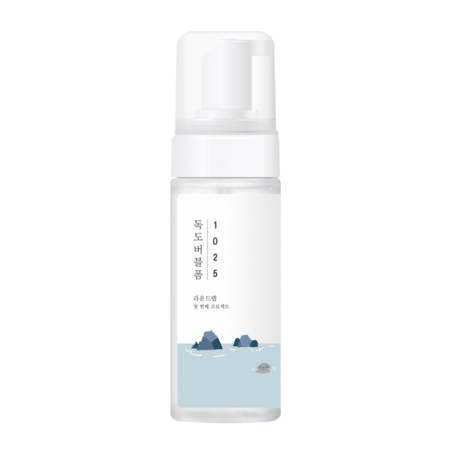 1025 Dokdo Bubble Foam" är en ansiktsrengöringsprodukt från ROUND LAB, förpackad i en vit pumpflaska med enkel och ren design, prydd med text och minimalistiska illustrationer av havslandskap.