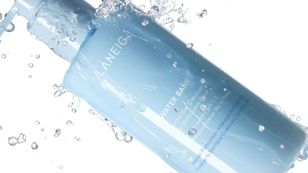 En stilren produktbild på Biodance Collagen Cleansing Oil i rosa transparent flaska mot ljus bakgrund med oljedroppar.