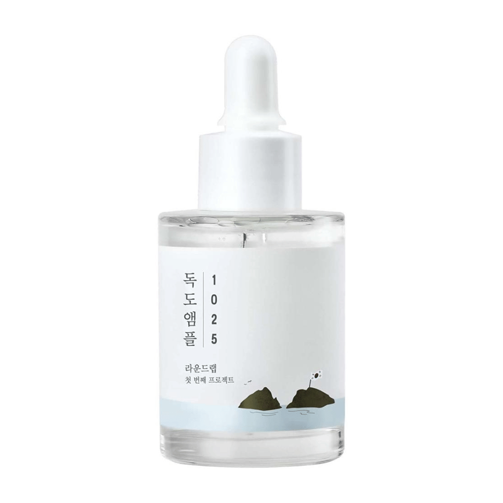 Una bottiglia trasparente di siero viso 1025 Dokdo Ampoule, decorata con un tema marino minimalista, su sfondo bianco.