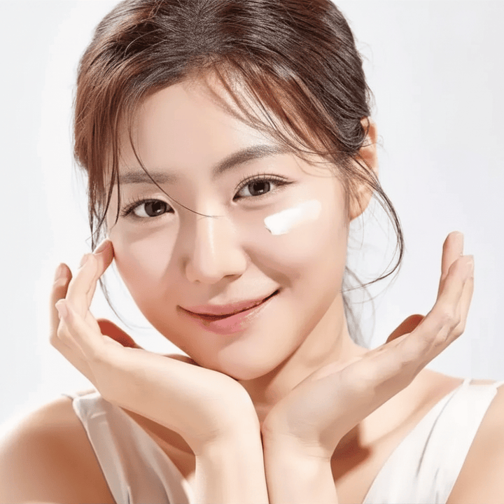 Donna applica Round Lab 1025 Dokdo Eye Cream sotto gli occhi per idratazione, luminosità e un incarnato più uniforme