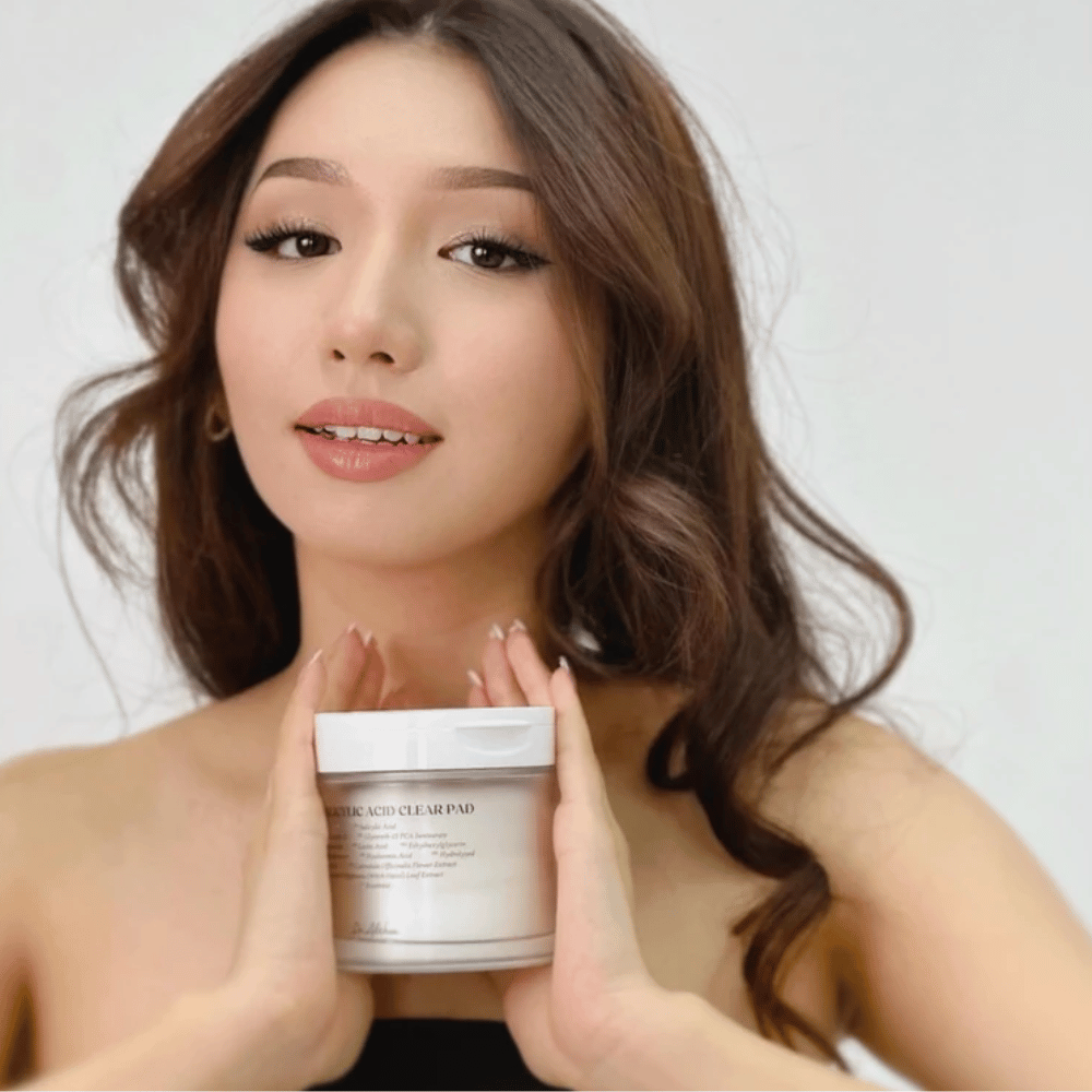 Il modello tiene Dr. Althea 2% Salicylic Acid Clear Pad davanti al viso. Tonico esfoliante pads con acido salicilico che puliscono i pori, bilanciano il sebo e donano una pelle più chiara.