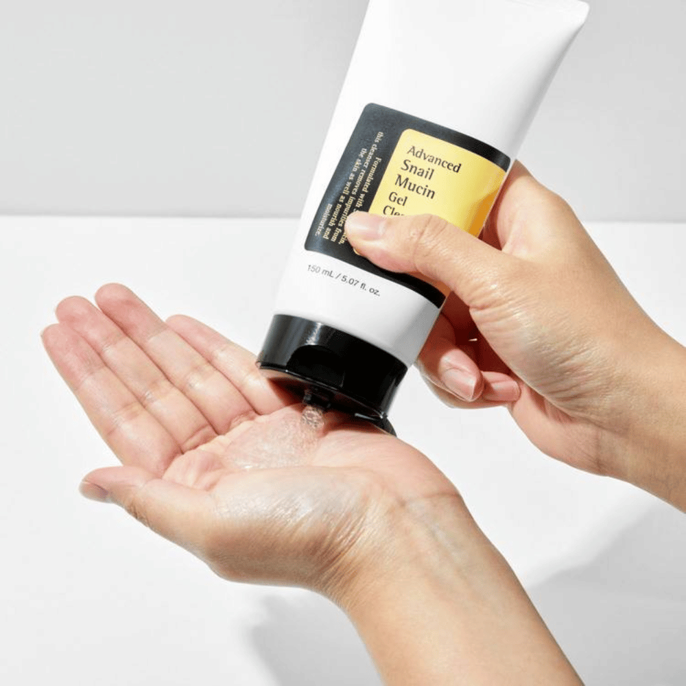 Mano applica COSRX Advanced Snail Mucin Gel Cleanser – detergente gel delicato con mucina di lumaca che pulisce in profondità e mantiene l'equilibrio idrico della pelle.
