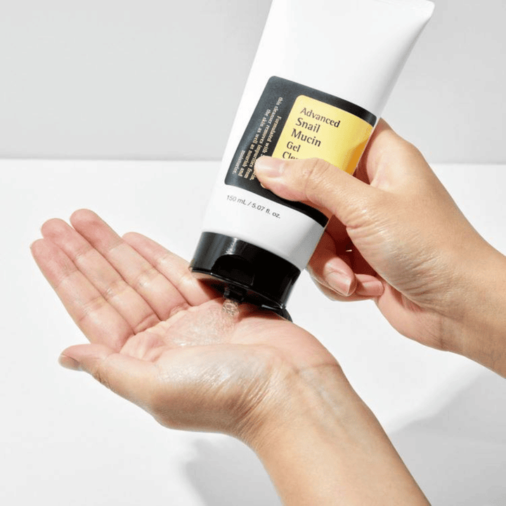 Mano applica COSRX Advanced Snail Mucin Gel Cleanser – detergente gel delicato con mucina di lumaca che pulisce in profondità e mantiene l'equilibrio idrico della pelle.