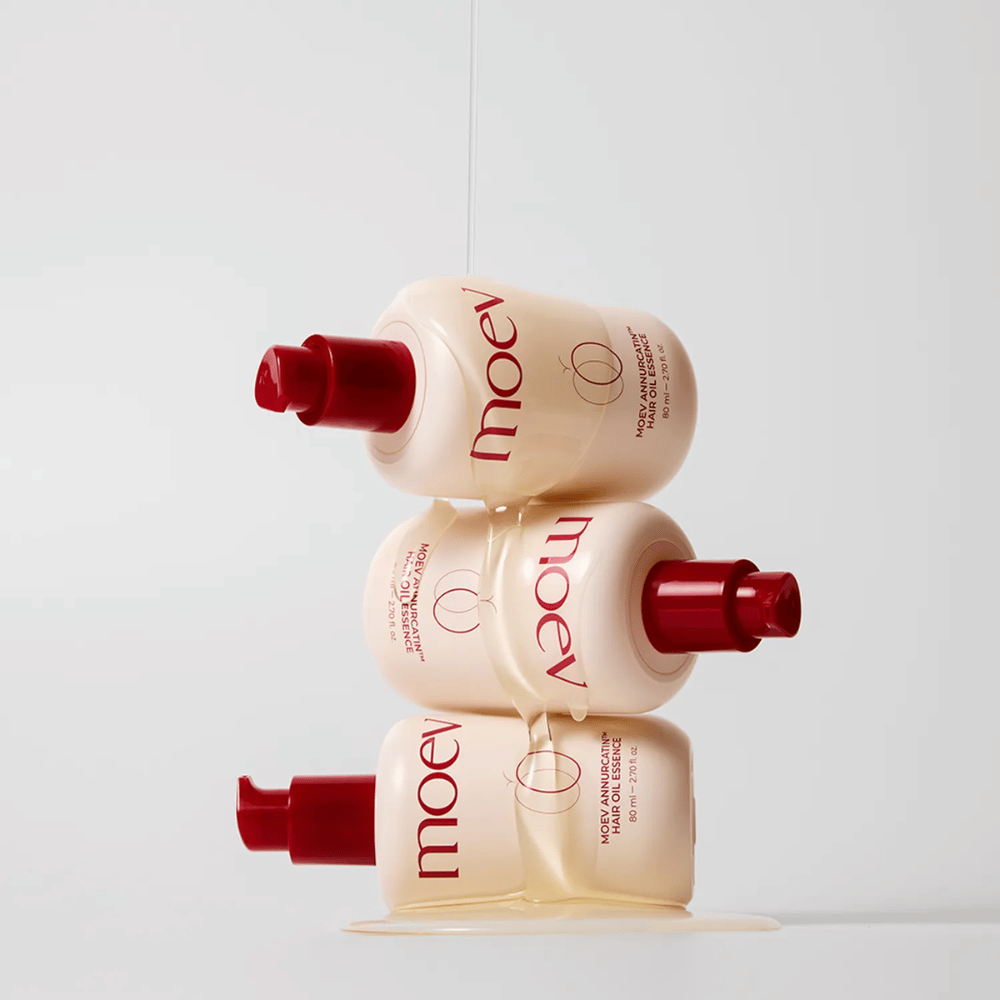 Tre bottiglie MOEV Annurcatin Hair Oil Essence impilate – olio per capelli nutriente con mela Annurca e biotina che rinforza, protegge e dona ai capelli lucentezza ed elasticità.