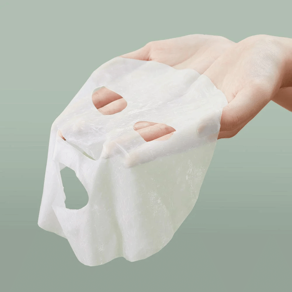 Una mano di una persona che tiene Anua Heartleaf 77% Soothing Sheet Mask.