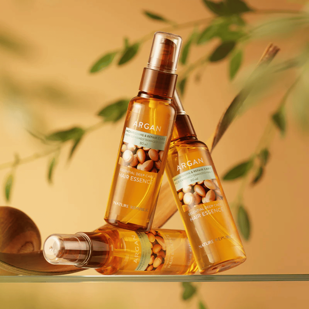 Tre bottiglie di Nature Republic Argan Essential Moisture Hair Oil con olio di argan – nutre, dona lucentezza e ripara i capelli danneggiati.