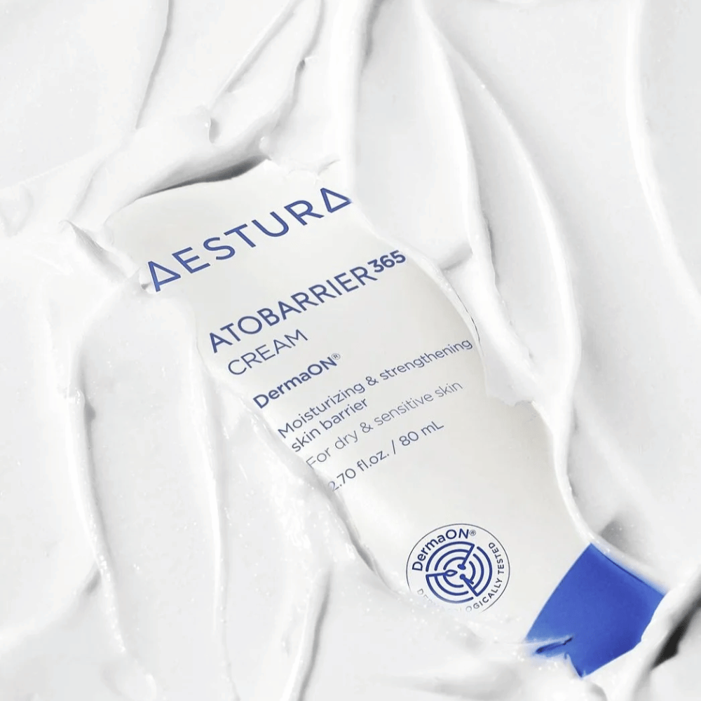 Aestura Atobarrier 365 Cream è perfetta per la pelle secca e sensibile. Con la tecnologia DermaON™, questa crema idrata e rafforza la barriera cutanea. Il prodotto è mostrato qui in un tubo da 80 ml, parzialmente coperto dalla sua stessa consistenza cremosa, che evidenzia le sue ricche proprietà idratanti.
