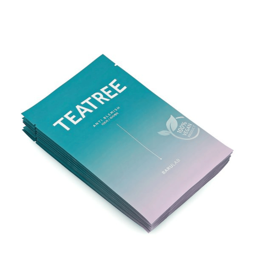 Una pila di confezioni di BARULAB maschere "TEATREE Anti Blemish", tutte contrassegnate come "100% Vegan Product". Le confezioni hanno un colore turchese uniforme.