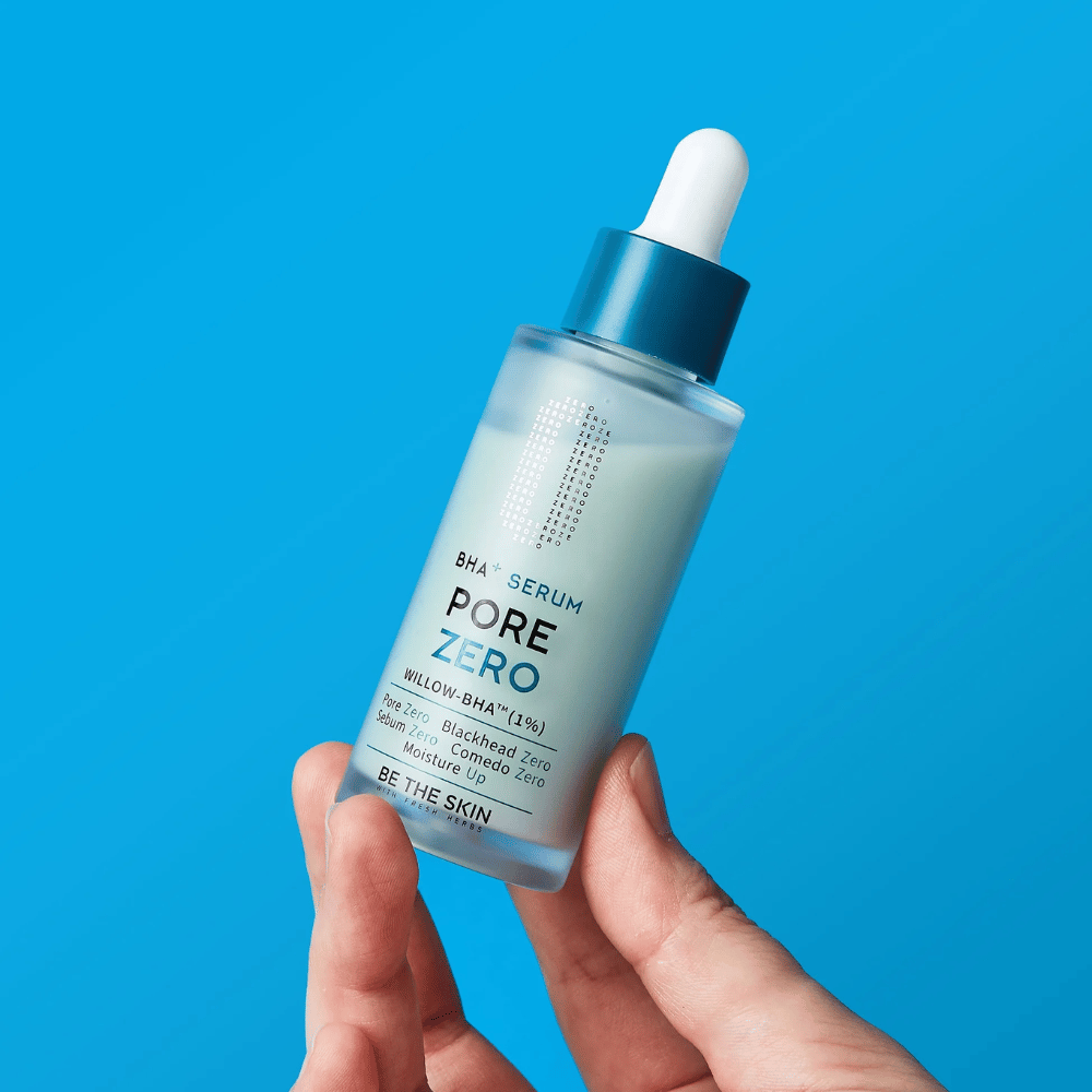 Be The Skin BHA+ Pore Zero Serum tenuto in mano su sfondo blu