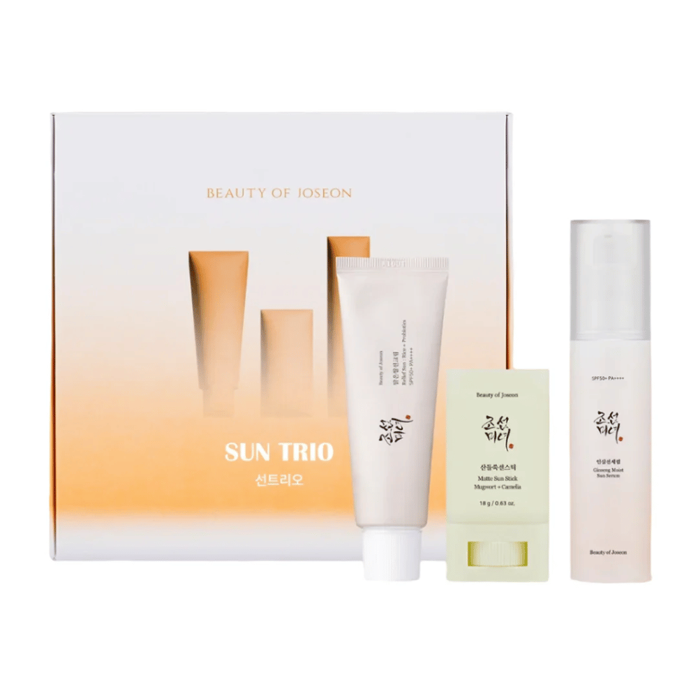 Beauty of Joseon - Sun Trio confezione regalo con tre prodotti solari: Relief Sun Rice + Probiotics, Matte Sun Stick Mugwort + Camellia e Ginseng Moist Sun Serum davanti a una confezione sfumata in bianco e arancione.