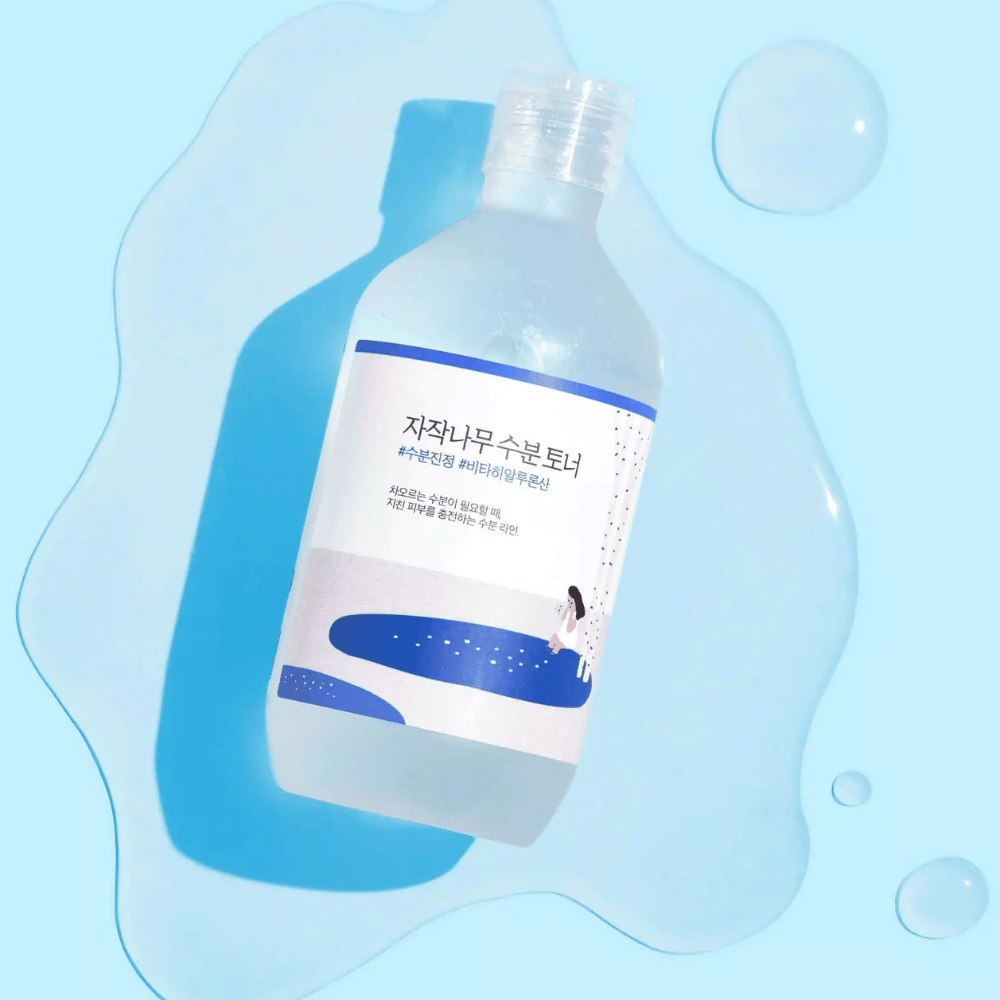 La bottiglia è inclinata in un liquido simile all'acqua con gocce tutt'intorno su sfondo blu