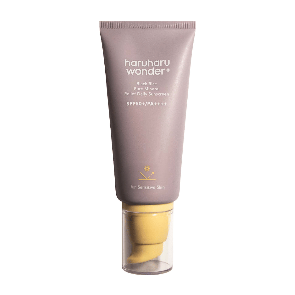 Un tubo viola con Haruharu Wonder Black Rice Pure Mineral Relief Daily Sunscreen SPF 50+ PA++++. Il tubo ha un tappo trasparente e un testo che descrive l'alto livello di protezione della crema solare, appositamente adattata per la pelle sensibile.