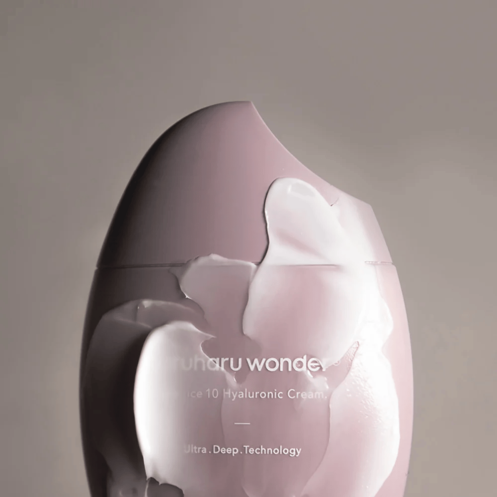 L'immagine mostra un barattolo con "Haruharu Wonder Black Rice 10 Hyaluronic Cream", che è parzialmente coperto da una crema densa e trasparente. Il testo sull'immagine suggerisce l'uso di tecnologia avanzata per l'idratazione profonda della pelle. Il design è moderno e minimalista.