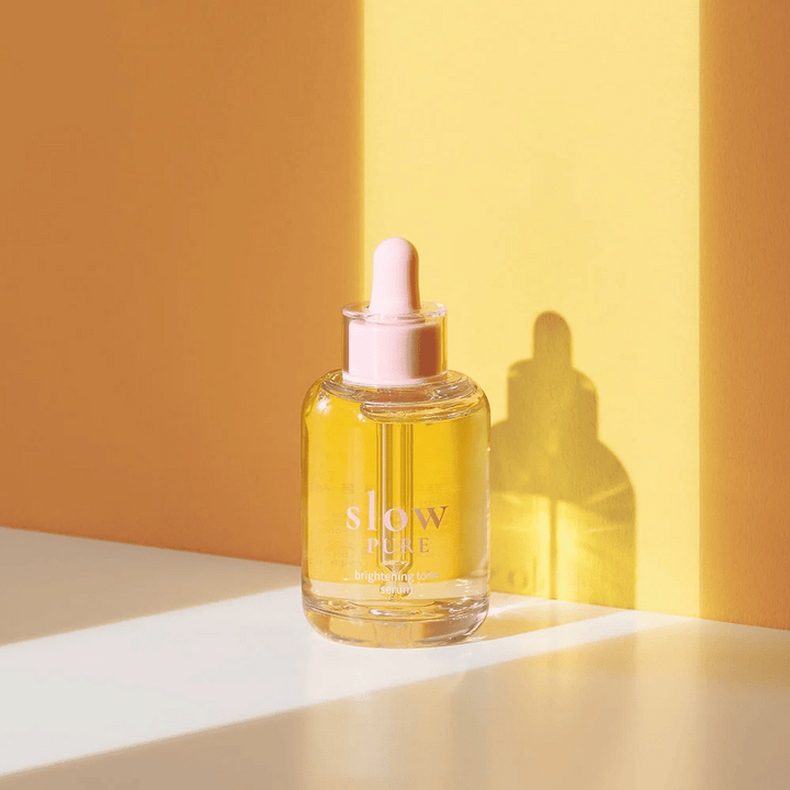 Slow Pure Brightening Tone Serum i soligt gult ljus, symboliserar lyster och energi för huden.