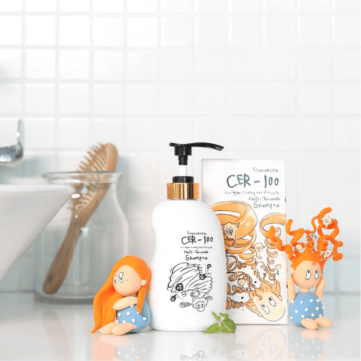 Elizavecca CER-100 Shampoo e la confezione in cartone sono mostrati in un ambiente da bagno accanto a una spazzola per capelli e figure decorative. L’immagine trasmette una routine quotidiana di cura dei capelli e l’uso del prodotto in ambiente domestico.