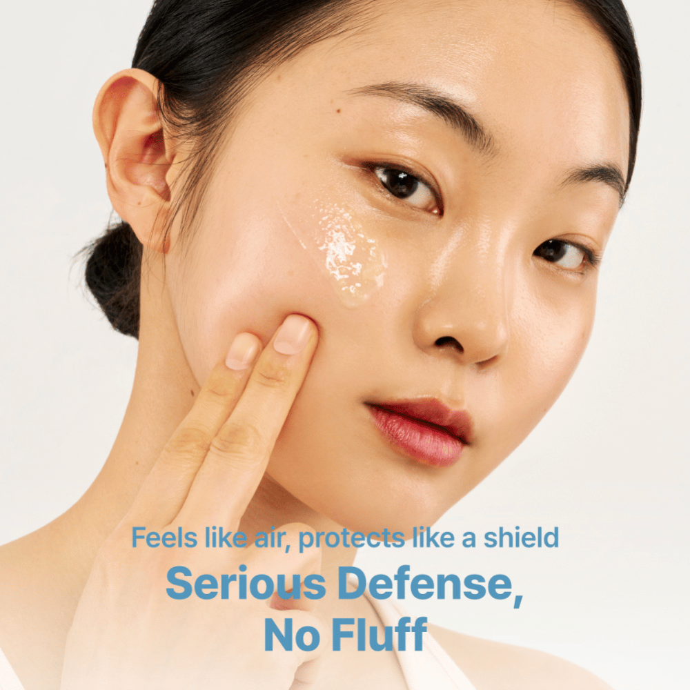 Tage Cica-Tree Water Jelly Sun Serum SPF 50+ viene applicato sulla guancia di una modella. Il gel trasparente dona alla pelle una finitura luminosa.