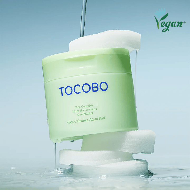TOCOBO Cica Calming Aqua Pad posizionato tra toner pads con essenza viso che scorre. Il simbolo vegan sottolinea la formulazione vegana del prodotto e il suo profilo delicato sulla pelle.