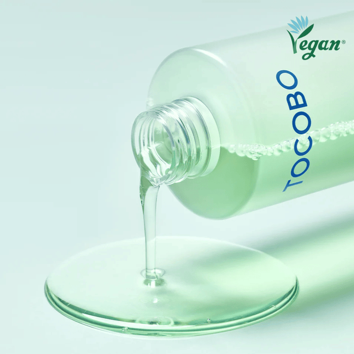 Primo piano di TOCOBO Cica Calming Aqua Toner versato per mettere in evidenza la consistenza chiara, leggera e rinfrescante del prodotto.