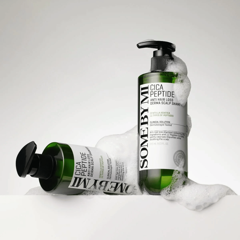 Due bottiglie di SOME BY MI Cica Peptide Anti Hair Loss Derma Scalp Shampoo coperte di schiuma, in piedi e sdraiate su sfondo bianco.