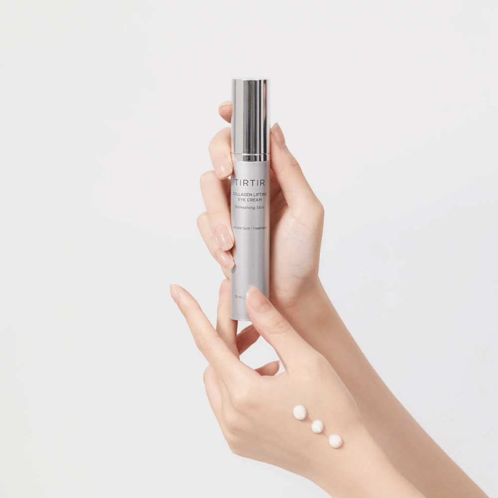 Mani che tengono un tubo con TIRTIR Collagen Lifting Eye Cream, con il prodotto spremuto sul dorso della mano.