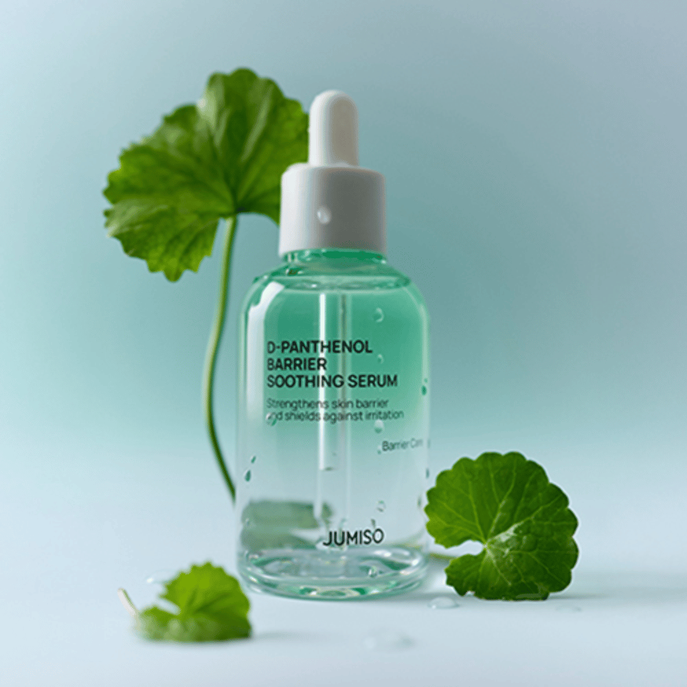 Jumiso D-Panthenol Barrier Soothing Serum in bottiglia di vetro trasparente con pipetta, posizionata con foglie verdi sullo sfondo.