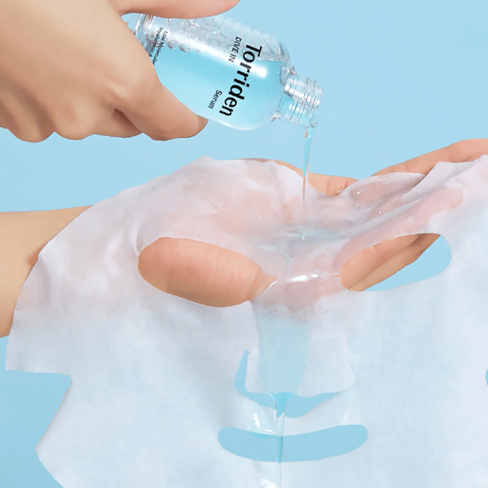 Maschera viso drabbassato con soluzione da una bottiglia "Torriden Dive-In", su sfondo blu.