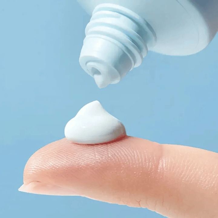 Primo piano di Torriden DIVE-IN Moisture Sun Cream con una texture morbida e idratante dosata sulla punta del dito per la protezione solare quotidiana.