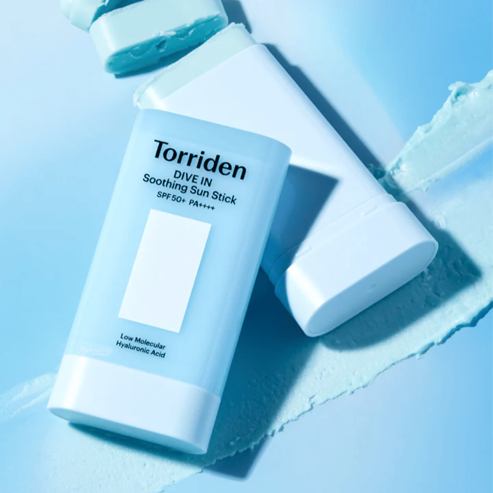 Torriden DIVE IN Soothing Sun Stick SPF50+ PA++++ insieme alla texture del prodotto spalmata che illustra l'applicazione idratante e leggera.