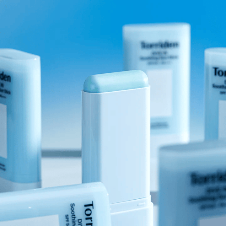 Primo piano di Torriden DIVE IN Soothing Sun Stick che mostra la morbida formula solare in formato stick con diversi prodotti sullo sfondo.