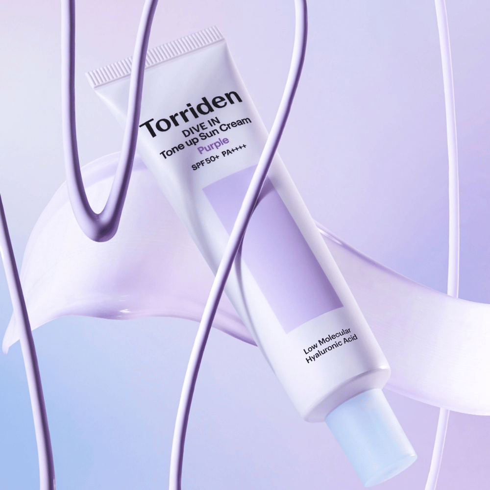 Torriden DIVE IN Tone Up Sun Cream Purple SPF50+ PA++++ presentato in un creativo contesto di prodotto con dettagli viola che mettono in risalto la formula idratante.