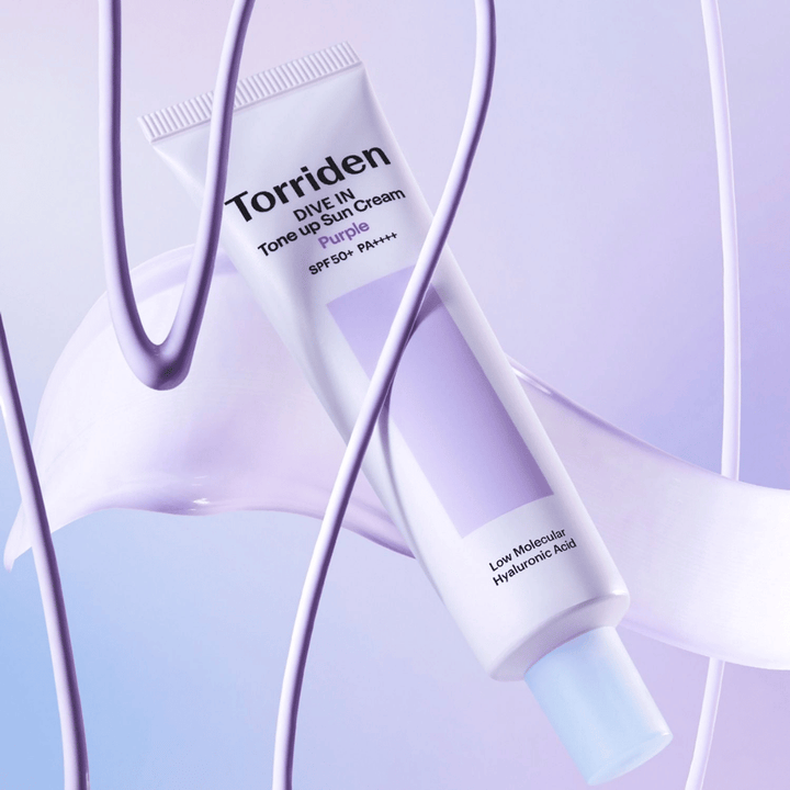 Torriden DIVE IN Tone Up Sun Cream Purple SPF50+ PA++++ presentato in un creativo contesto di prodotto con dettagli viola che mettono in risalto la formula idratante.