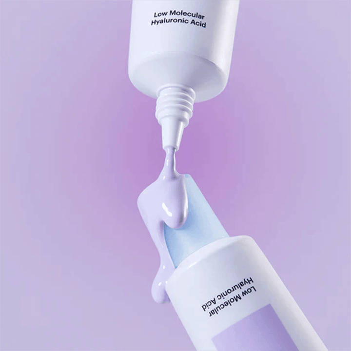 Primo piano di Torriden DIVE IN Tone Up Sun Cream Purple in cui la crema viola viene applicata dal tubetto per illustrare la consistenza del prodotto.