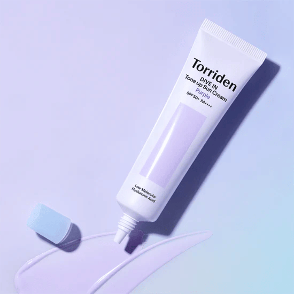 Tubetto aperto di Torriden DIVE IN Tone Up Sun Cream Purple con texture di crema solare tinta di viola che mostra la formula correttiva del colore del prodotto.