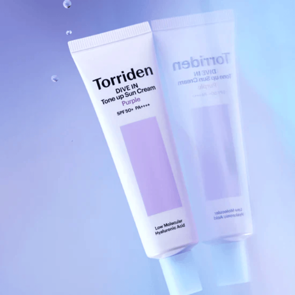 Torriden DIVE IN Tone Up Sun Cream Purple SPF50+ PA++++ fotografato su uno sfondo viola tenue che mette in risalto il design riflettente della luce del prodotto.