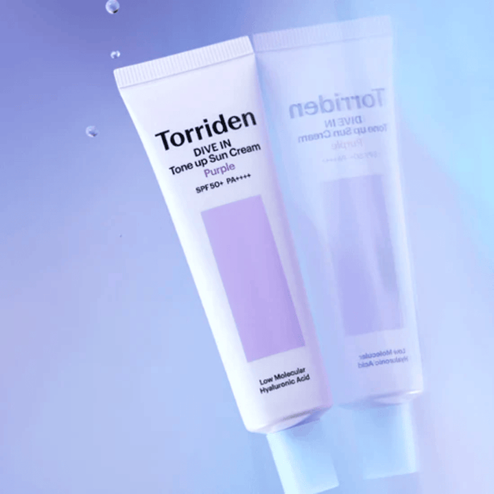 Torriden DIVE IN Tone Up Sun Cream Purple SPF50+ PA++++ fotografato su uno sfondo viola tenue che mette in risalto il design riflettente della luce del prodotto.