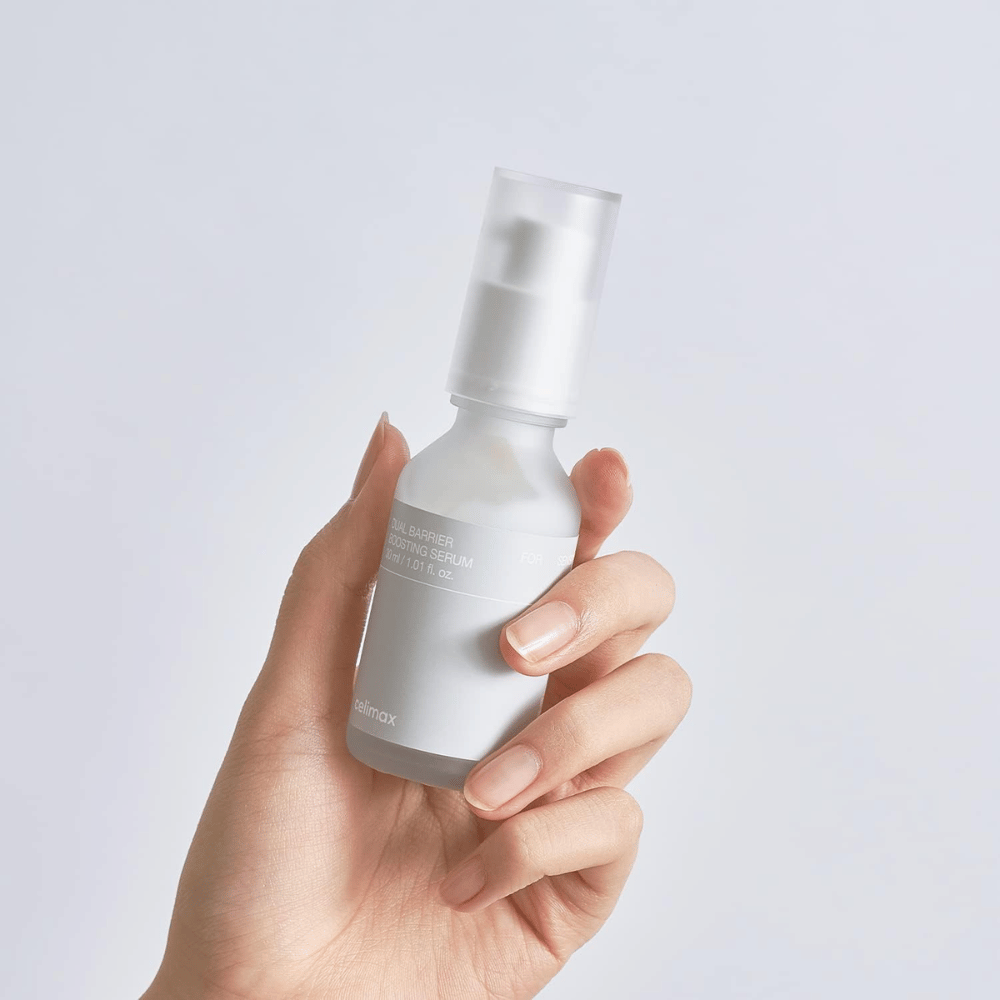 Celimax Dual Barrier Boosting Serum in mano, confezione minimalista che mostra siero coreano rafforzante per la barriera per la pelle sensibile.