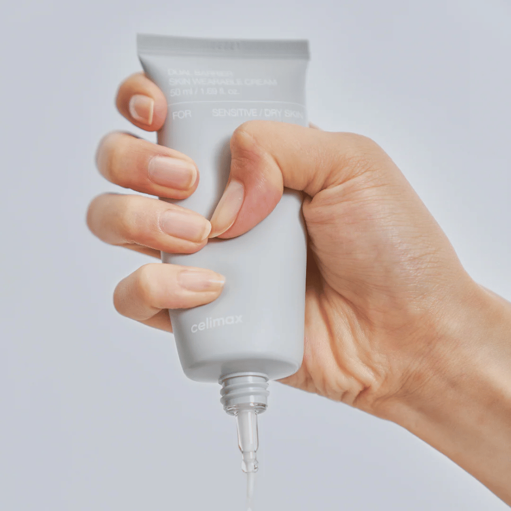 Mano che applica Celimax Dual Barrier Skin Wearable Cream, crema viso che rafforza la barriera per pelle sensibile e secca che fornisce idratazione a lungo termine e protegge la barriera cutanea.