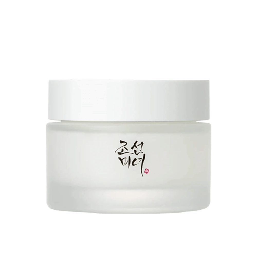 L'immagine mostra un barattolo "Beauty of Joseon Dynasty Cream". La confezione è in vetro smerigliato con un semplice coperchio bianco, elegantemente decorato con calligrafia tradizionale coreana in nero. Il prodotto è destinato a offrire cura della pelle nutriente ispirata alle antiche routine di bellezza coreane.
