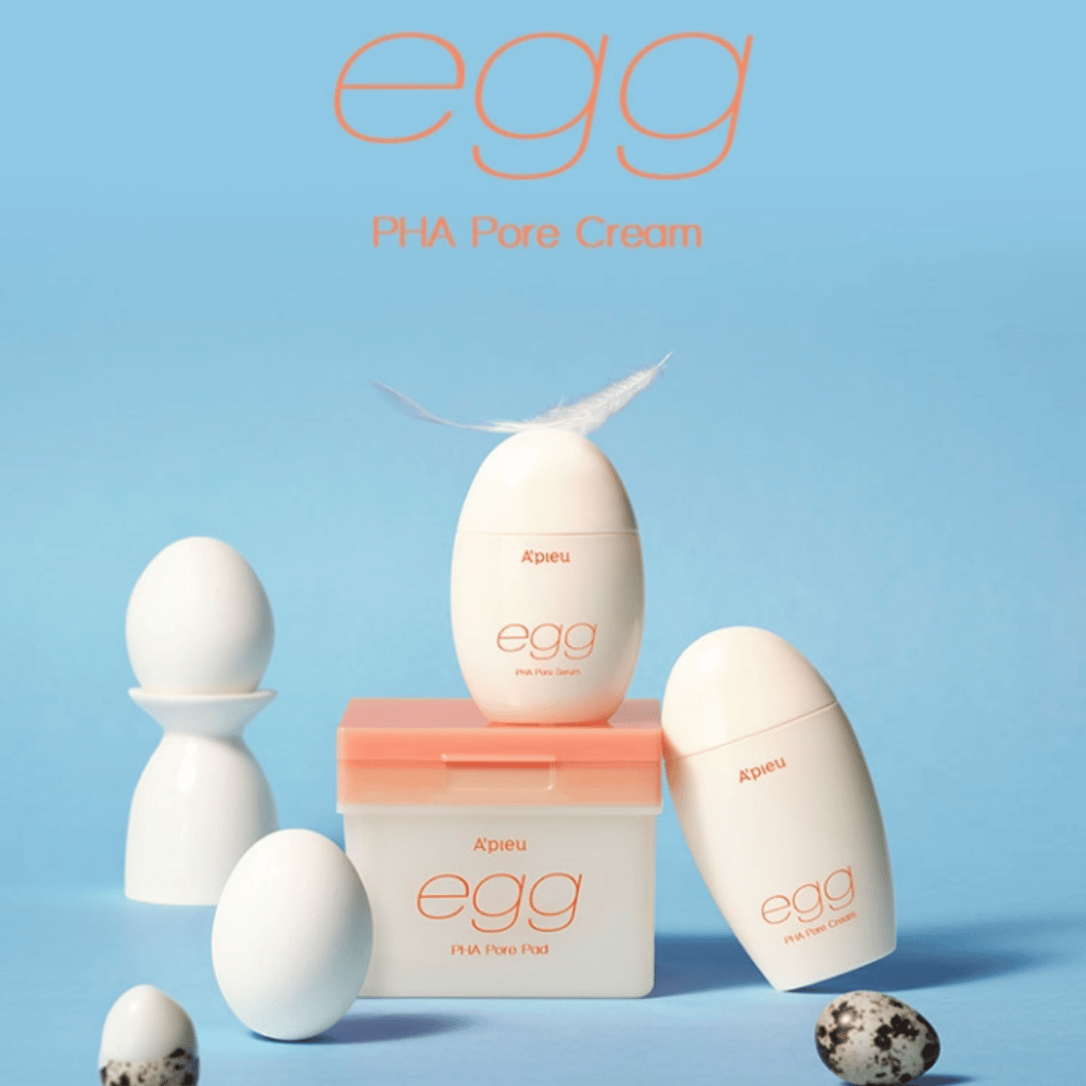 A'pieu Egg PHA Pore-serie – prodotti a forma di uovo come siero, crema e pads, elegantemente disposti su sfondo blu con uova e piume che simboleggiano una cura della pelle delicata.