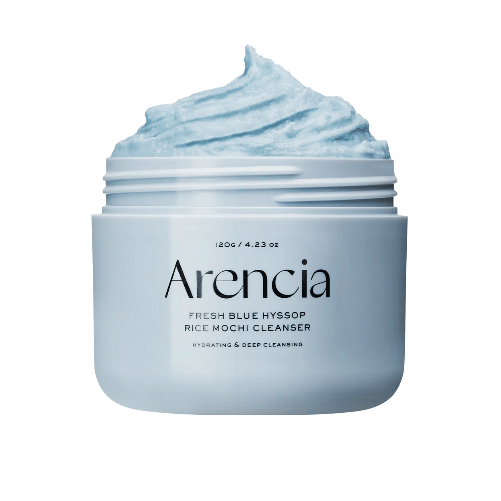 Primo piano di un barattolo aperto Arencia Fresh Blue Hyssop Rice Mochi Cleanser. La crema detergente blu ha una consistenza ariosa e montata e riempie la parte superiore del barattolo.