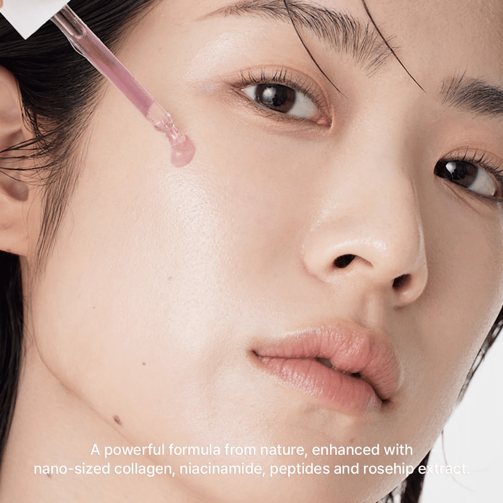 Primo piano di un viso dove Arencia Red Smoothie Serum 8 viene applicato con pipetta. Il siero ha una leggera tonalità rosa e contiene nano-collagene, niacinamide, peptidi ed estratto di rosa canina.