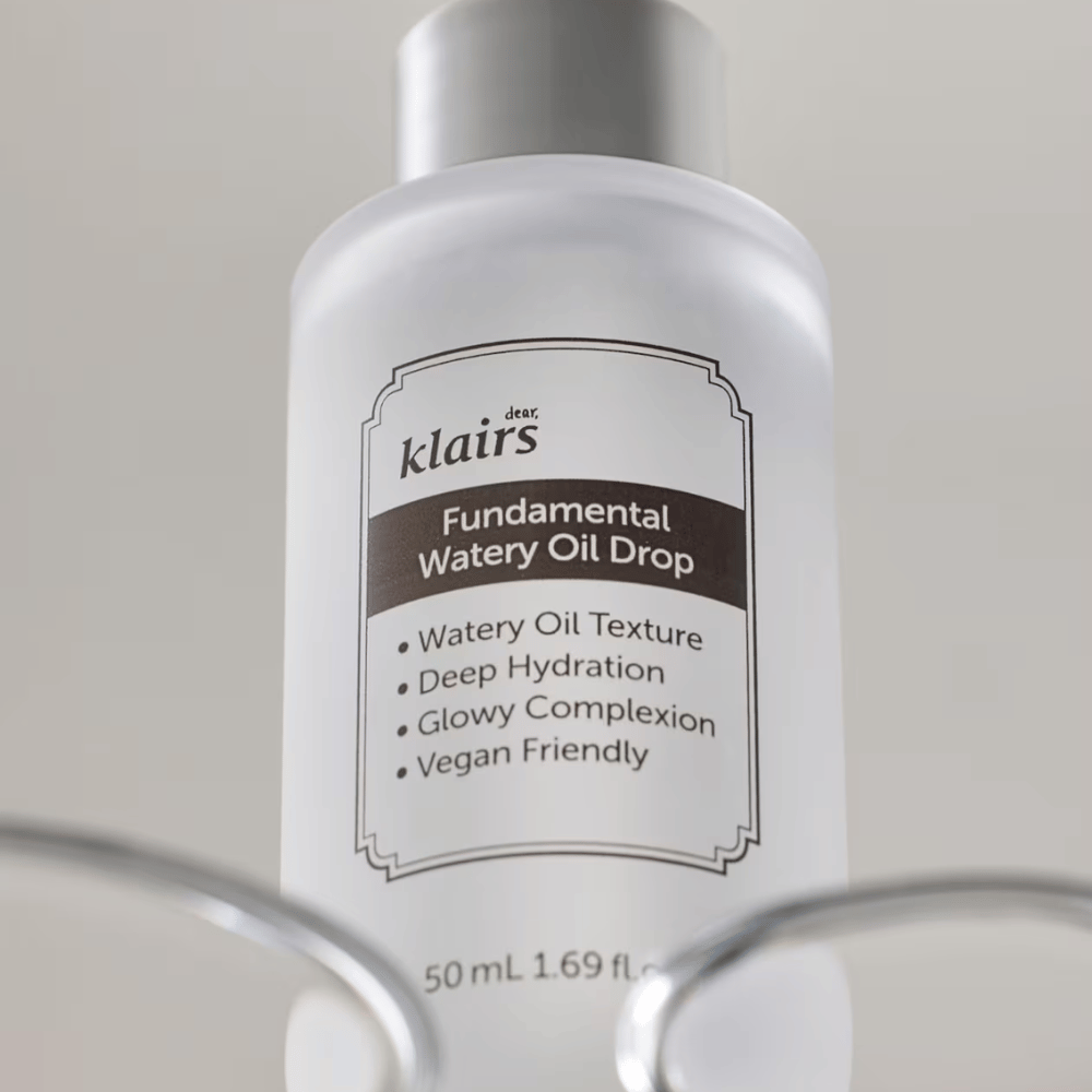Flacone con Klairs Fundamental Watery Oil Drop, 50 ml, posizionato in un supporto trasparente, con etichetta chiara che evidenzia le proprietà idratanti e vegane del prodotto.