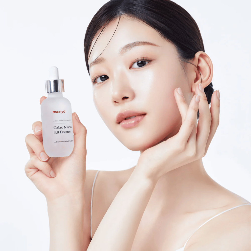 Donna con pelle radiosa tiene Ma:nyo Galac Niacin 3.0 Essence – essence coreano che dona un tono della pelle più uniforme e una luminosità naturale.