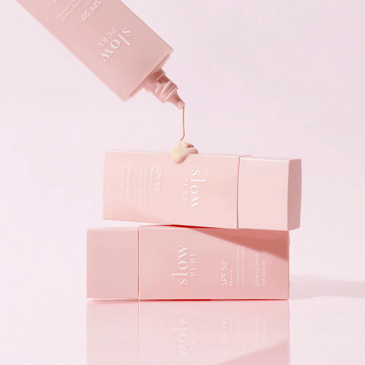 Slow Pure Glow Up Fluid Sun Serum med kräm pressad ur flaskan, visar lätt och vårdande konsistens.