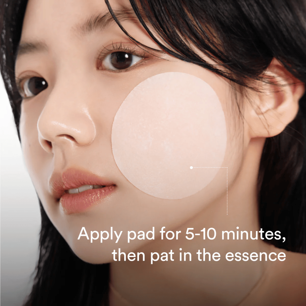 Donna applica un pad rotondo tonico viso sulla guancia per una cura della pelle idratante e illuminante.