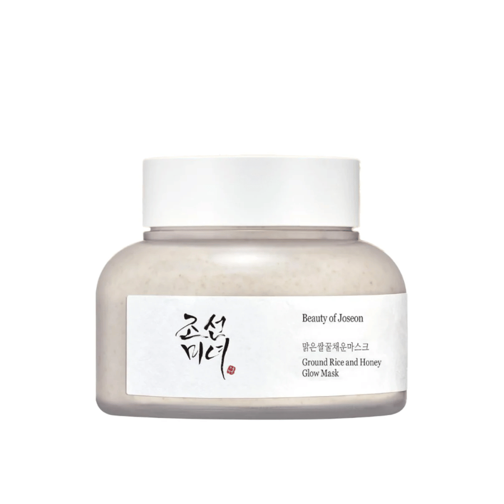 Un barattolo "Beauty of Joseon Ground Rice and Honey Glow Mask". La confezione è semplice con un tappo bianco e un'etichetta che presenta il nome del prodotto e gli ingredienti sia in coreano che in inglese. Il prodotto è progettato per dare luminosità e nutrimento alla pelle.