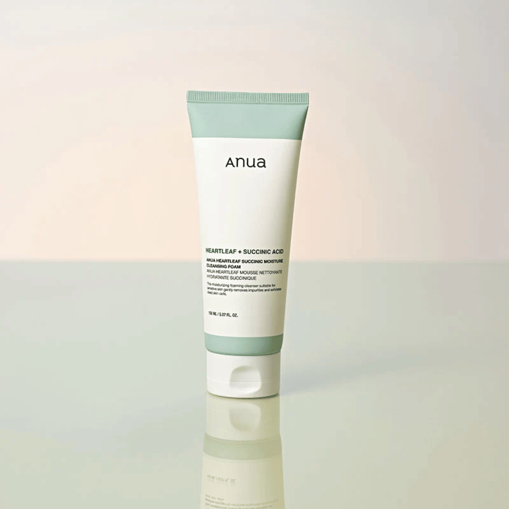Immagine del prodotto isolato di Anua Heartleaf + Succinic Acid Moisture Cleansing Foam. Il prodotto è mostrato in piedi su una superficie riflettente che mette chiaramente in risalto il design della confezione e l'estetica minimalista del marchio.