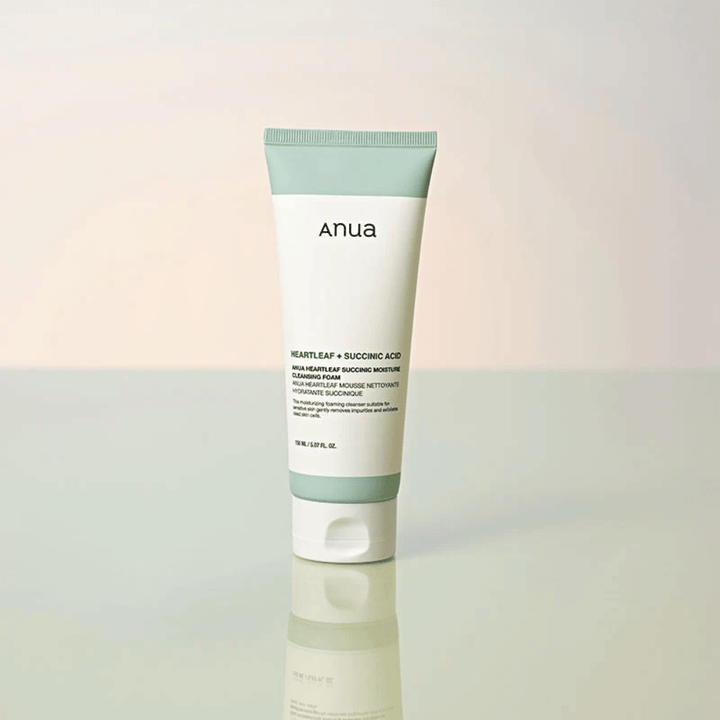 Immagine del prodotto isolato di Anua Heartleaf + Succinic Acid Moisture Cleansing Foam. Il prodotto è mostrato in piedi su una superficie riflettente che mette chiaramente in risalto il design della confezione e l'estetica minimalista del marchio.