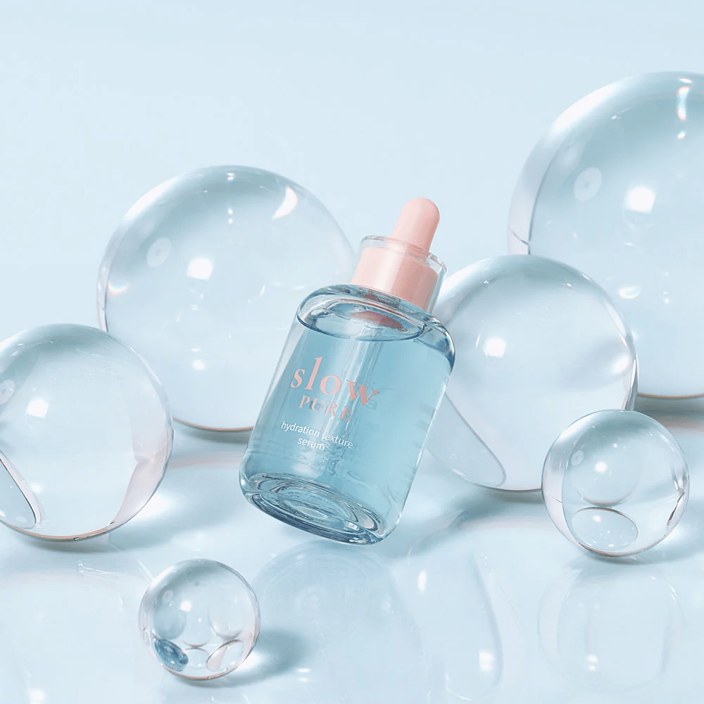 Slow Pure Hydration Texture Serum posizionata tra bolle trasparenti, simbolo di idratazione intensa.